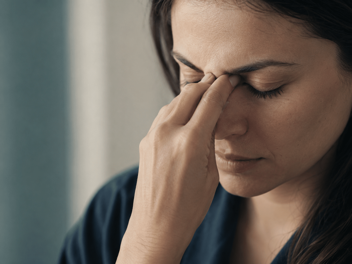 Mulher com dor de cabeça e pressão nos seios da face, sintomas de sinusite